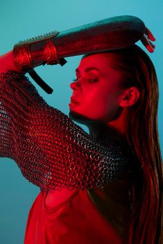 attractive woman Glamor posing red light metal armor on hand Lifestyle unaltered. High quality photo