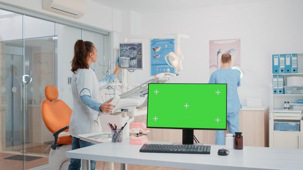 Dentist office with green screen on monitor and dental tools. Computer with isolated background and mockup template in cabinet for oral care and dentition. Medical space for dentistry