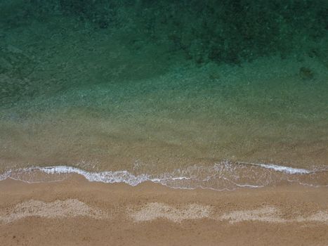 Timelapse. Beautiful remote beach with crystal clear water, aerial view. People sunbathe and swim on the pebble beach. Untouched nature, clean water. Rocky shore and hidden beach