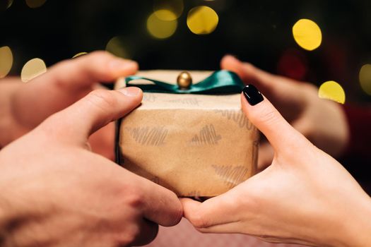 Men's hands give different box with a gift to a woman. Person holding gift box. Concept of family holidays, perfect Christmas, New Year, celebration.