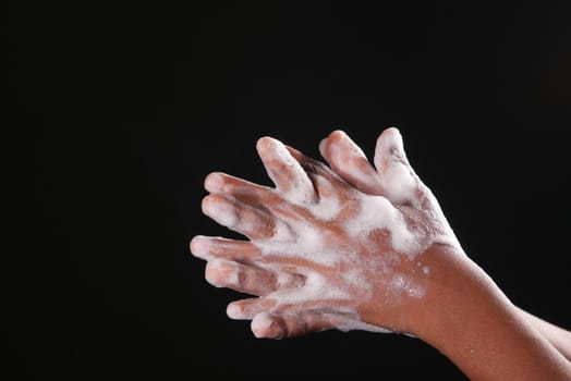 young man washing hands with soap warm water.