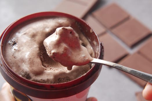 close up of chocolate flavor ice cream in a container .