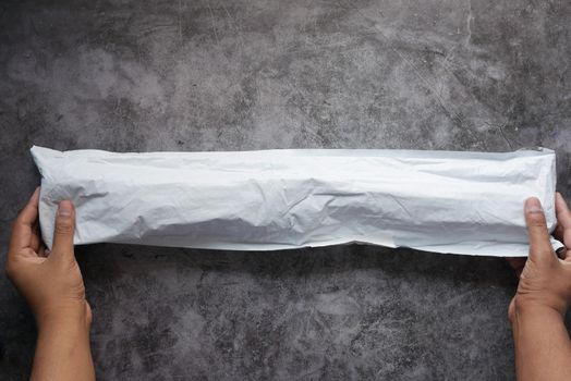 holding a delivery envelope on black background .