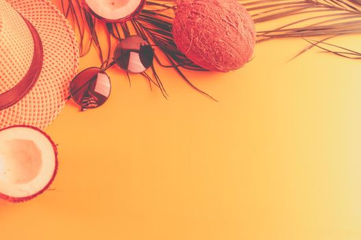 Summer composition with neon lights. Tropical palm leaves, hat, glasses and broken coconut on a sandy background. The concept of the summer season, parties and heat. Flat lay, top view, copy space