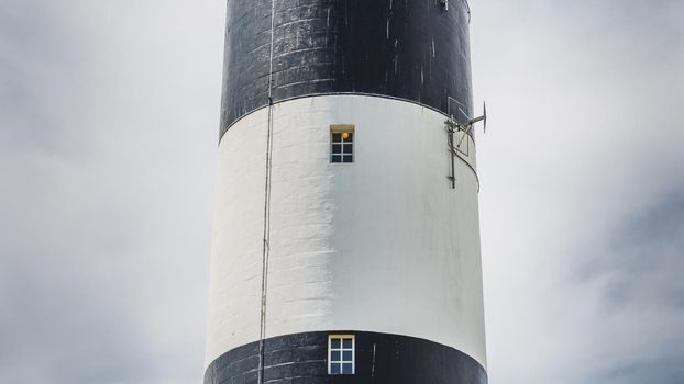 The Chassiron lighthouse with black and white stripes on blue sky, on the island of Oléron in France