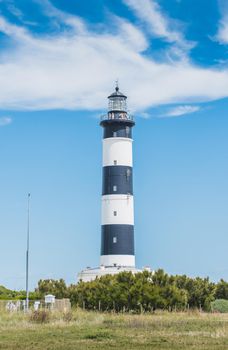The Chassiron lighthouse with black and white stripes on blue sky, on the island of Oléron in France