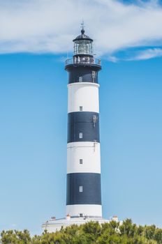 The Chassiron lighthouse with black and white stripes on blue sky, on the island of Oléron in France