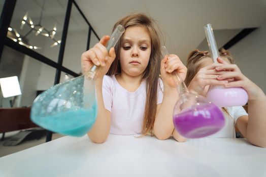 Girls making chemical experiments at home, close view.