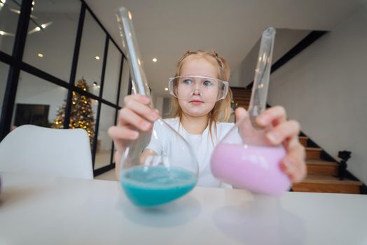 Girl making chemical experiments at home, close view.