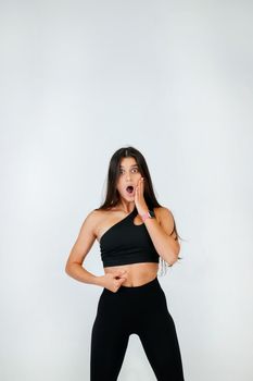 Young woman showing fat on her belly over white background. Lifestyle, sport, diet concept.