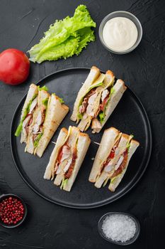 Homemade turkey club sandwich, on black background, top view