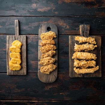 Crispy fried chicken parts on old dark wooden table, top view.