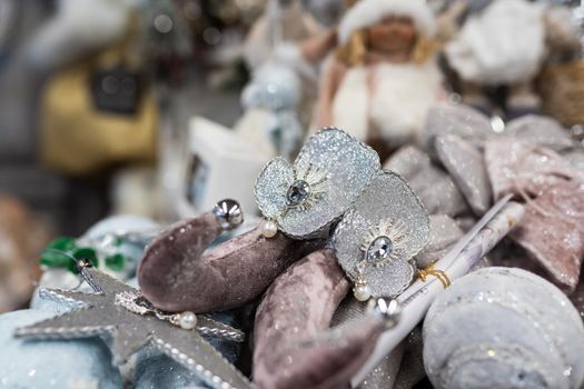 Close up of different object toy gifts hanging from a decorated Christmas tree.