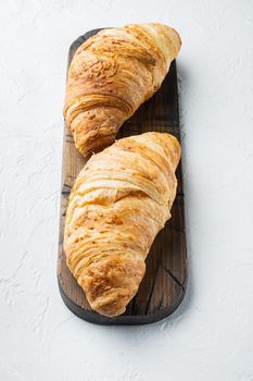 Crispy fresh croissants set, on white stone background