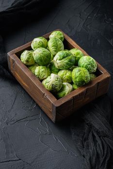 Raw brussels sprouts, on black textured background
