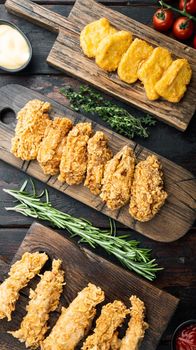 Crispy kentucky fried chicken cuts on dark wooden background, top view.