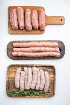 Fresh raw pork, beef and chicken sausages, top view, on white background.