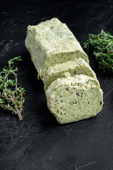 Homemade Organic Herb Butter with Rosemary Thyme and garlic set, on black stone background, with copy space for text