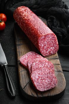 Salami with herbs , garlic set, on black wooden table background