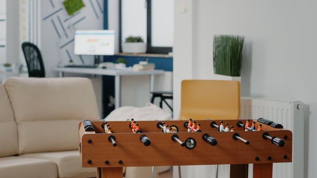 Empty business office used for after work meeting with drinks. Nobody in corporate workplace with foosball table to play soccer game. Space to do fun activity and entertainment after hours