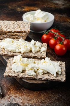 Crisp bread with cream cheese set, on old dark rustic table background