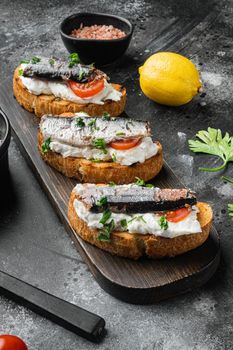 Sandwich with smoked fish set, on black dark stone table background