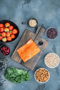 Organic food for healthy nutrition, superfoods, flat lay, on grey background.