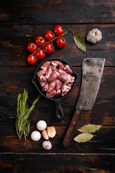 Raw uncooked chicken gizzards, chicken hearts set, on old dark wooden table background, top view flat lay