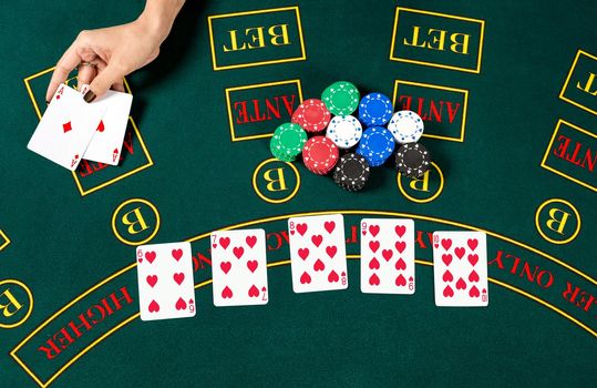 Poker play. Chips in a player's hand. top view. two aces, a winning combination. female hands