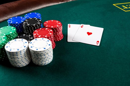 Poker play. Chips and cards on the green table