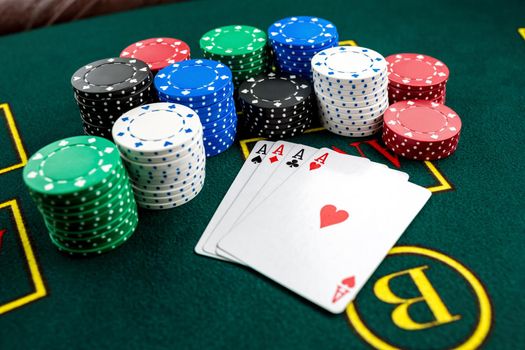 Poker play. Chips and cards on the green table