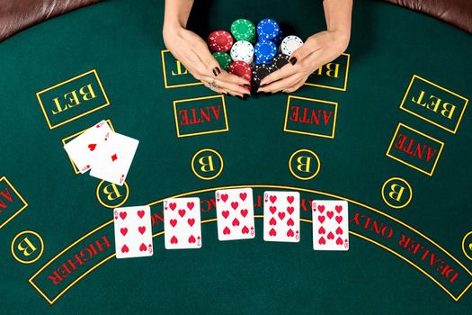 Poker play. Chips in a player's hand. top view. the player wins. female hands take the chips are won