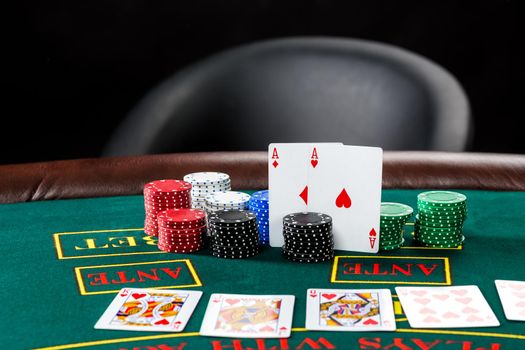 Poker play. Chips and cards on the green table