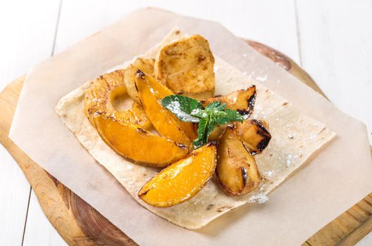 Fruits grilled with mint close up on a wooden board on white table. Takeaway composition