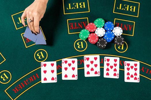 Poker play. Chips in a player's hand. top view. female hand lifts the cards to see