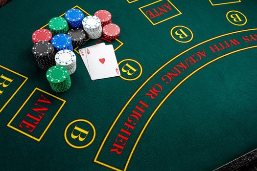 Poker play. Chips and cards on the green table