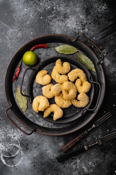Breaded shrimp ready to cook set, on black dark stone table background, top view flat lay, with copy space for text