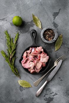 Raw uncooked chicken gizzards, stomach set, on gray stone table background, top view flat lay