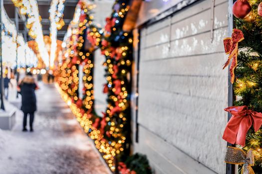 Christmas or New Year's market in a European city with houses decorated with toy balls and garlands at night.