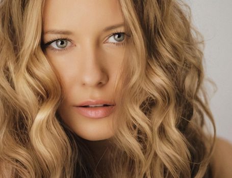 Hairstyle model and beauty face closeup. Beautiful blonde woman with long straight blond hair styled in curly waves, classic glamour style and luxury fashion portrait.