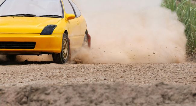 Rally race car drifting on dirt track.