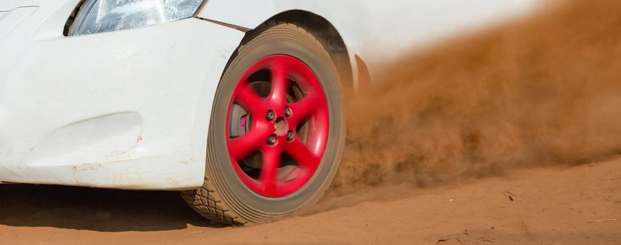 Rally race car drifting on dirt track.