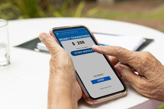 Elderly woman confused and  trying to transfer money on mobile phone