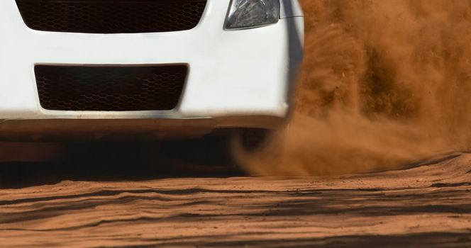 Rally race car drifting on dirt track.