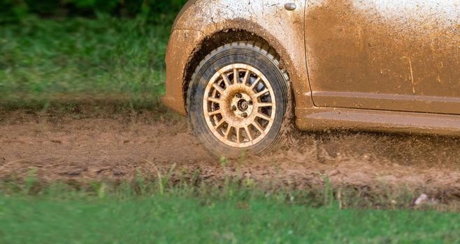 Rally racing car on muddy track.