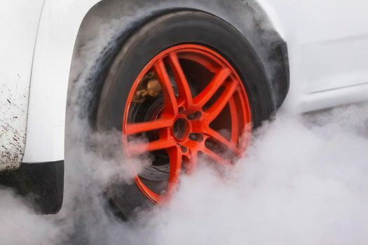 Drag racing car burns rubber off its tires in preparation for the race