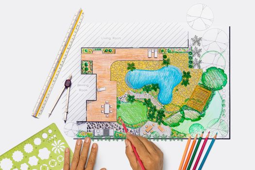 Landscape architect student designing backyard garden and pool plan for villa.