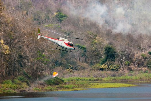 Fire fighting helicopter carry water for extinguish forest fire