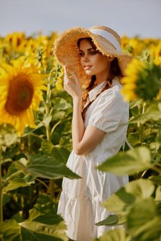 woman portrait walks through a field of sunflowers Summer time. High quality photo