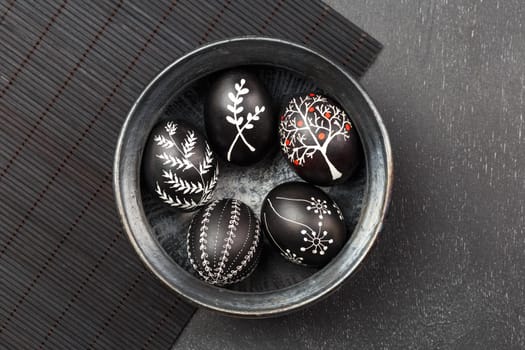 Black monochrome Easter greeting card with handmade wax dyed pysanka eggs in a bowl